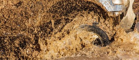 SUV wheel stalled in mud and water.の写真素材