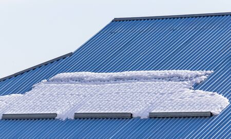 Snow on the roof tiles of the house.の写真素材