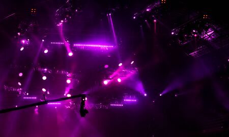 Purple light on a rock concert stage as background.