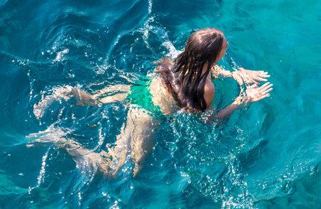 Bodrum, Turkey - August 21, 2019: A girl swims in the Aegean Sea in Turkey.のeditorial素材