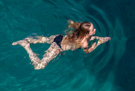 Bodrum, Turkey - August 21, 2019: A girl swims in the Aegean Sea in Turkey.のeditorial素材