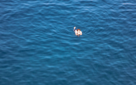 Bodrum, Turkey - August 21, 2019: A girl swims in the Aegean Sea in Turkey.のeditorial素材