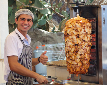 Bodrum, Turkey - August 21, 2019: A man cooks grilled chicken meat.のeditorial素材