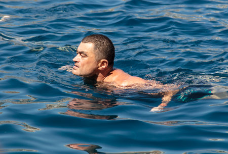 Bodrum, Turkey - August 21, 2019: A man swims in the water of the Aegean Sea in Turkey.