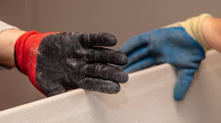 Gloves on the hands of a worker at a construction site.