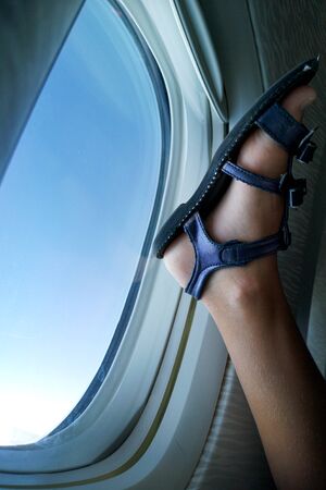Leg of a boy on a plane porthole.の写真素材