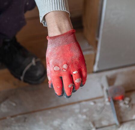 Gloves on the hands of a worker at a construction site.