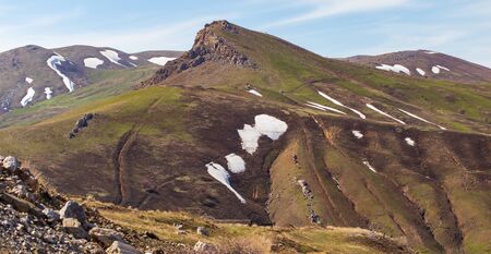 Snow on the slopes of the mountains .