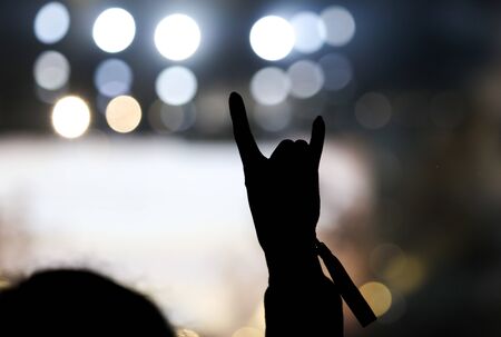 Hand silhouette at a rock concert as background.
