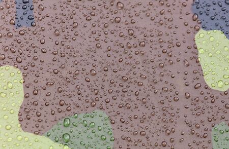 Raindrops on khaki color tent as abstract background .