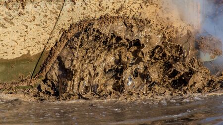SUV wheel stalled in mud and water.