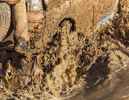 SUV wheel stalled in mud and water.