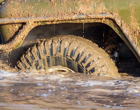 SUV wheel stalled in mud and water.
