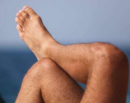 Legs of a man with a sea view.