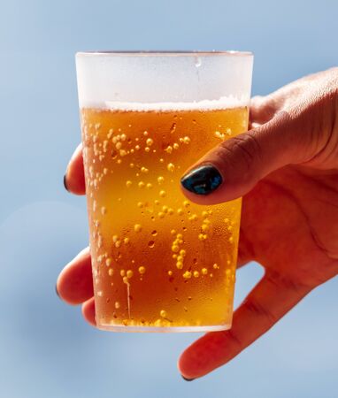Glass with beer in the girlâs hand.の写真素材