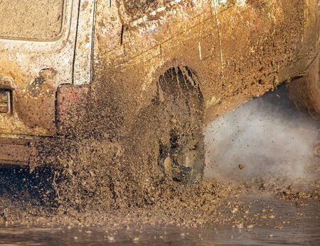 SUV wheel stalled in mud and water.