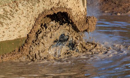 SUV wheel stalled in mud and water.
