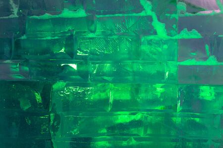 Ice bricks backlit in green as a background.の写真素材