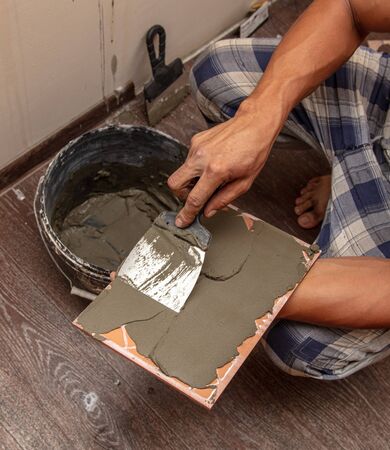Worker glues tiles on the wall.の写真素材