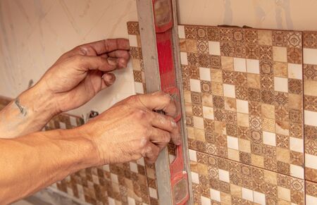 Worker glues tiles on the wall.の写真素材
