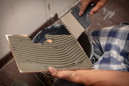 Worker glues tiles on the wall.の写真素材