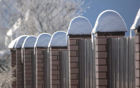 Brick fence in the snow in winter.の写真素材