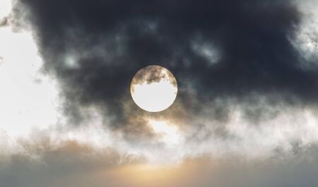 The sun in the sky behind the clouds.の写真素材