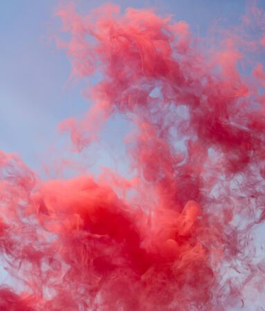 Red smoke on a blue sky.