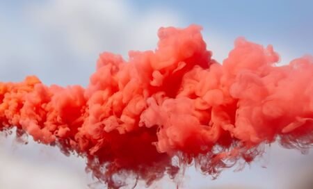 Red smoke on a blue sky.の写真素材