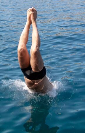 A man swims in the blue water of the sea.の写真素材
