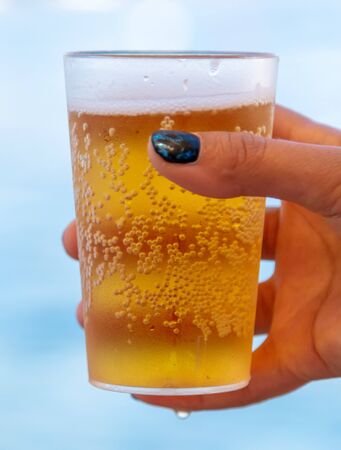 Glass with beer in the girlâs hand.の写真素材