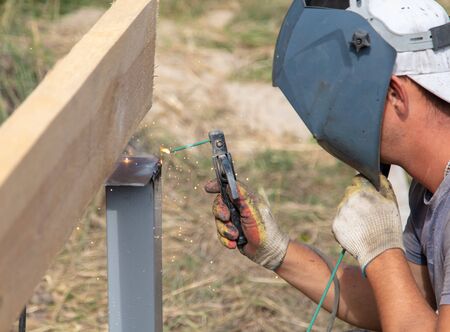 Worker welds metal at a construction site.
