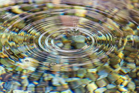 Circles on the surface of clear water in a pond as an abstract background.の写真素材
