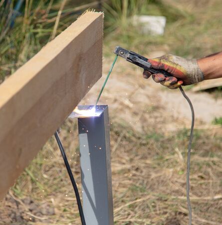 Worker welds metal at a construction site.