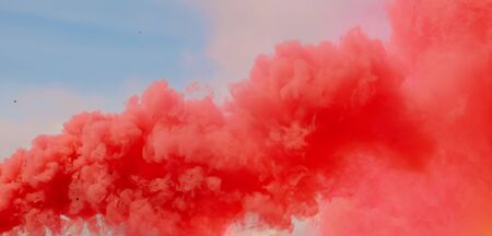 Red smoke on a blue sky.の写真素材