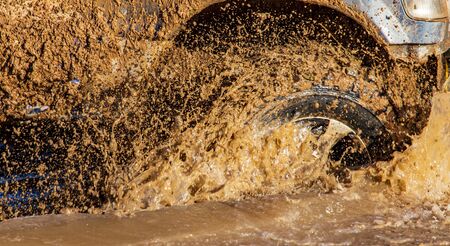 SUV wheel stalled in mud and water.の写真素材