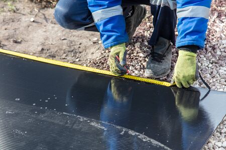 A worker mounts plastic at a construction site.の写真素材