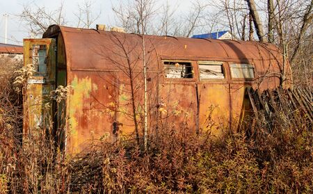 Rusty metal trailer at the cottage in the fall.