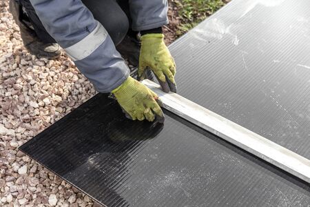 A worker mounts plastic at a construction site.