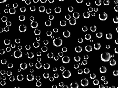 Air balls in water on a black background. Macro