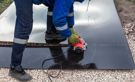A worker mounts plastic at a construction site.の写真素材