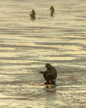 Lipetsk, Russia - December 6, 2019: Guys catch fish on ice in the morning at the Matyr reservoir.のeditorial素材