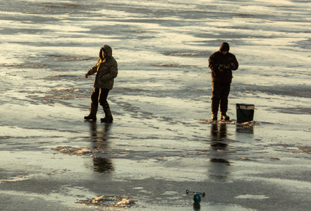 Lipetsk, Russia - December 6, 2019: Guys catch fish on ice in the morning at the Matyr reservoir.のeditorial素材
