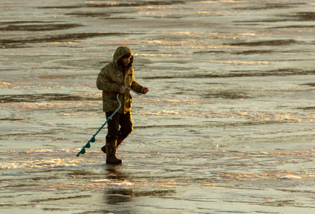 Lipetsk, Russia - December 6, 2019: A man catches fish on ice in the morning at the Matyr reservoir.のeditorial素材