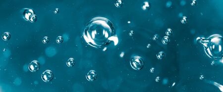 Bubbles of air on the smooth surface of blue water as an abstract background .