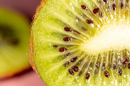 Seeds on a sliced green kiwi as a background. Macroの写真素材