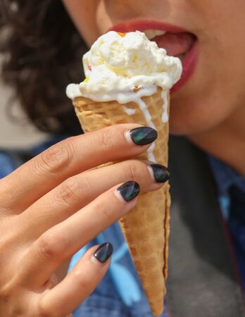 Girl eats an ice cream cone.