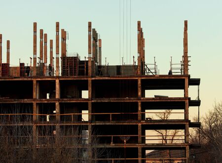 The construction of a multi-storey building at dawn.