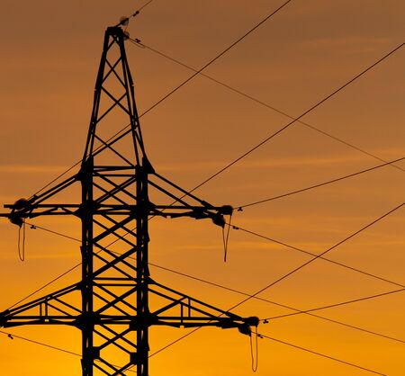 Electric pole with wires on a sunset background.