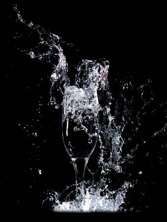 Water with splashes in a glass on a black background.の写真素材